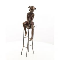 A RESIN FIGURINE OF A LITTLE GIRL ON STOOL