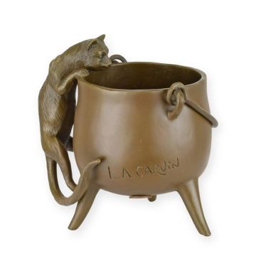A BRONZE SCULPTURE OF A CAT CLIMBING IN A POT