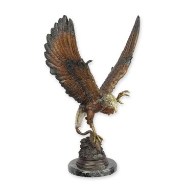 A BRONZE SCULPTURE OF AN EAGLE CATCHING PREY