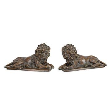 A BRONZE PAIR OF RECLINING LIONS