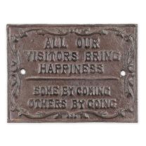 A CAST IRON "ALL OUR VISITORS BRING HAPPINESS" PLAQUE