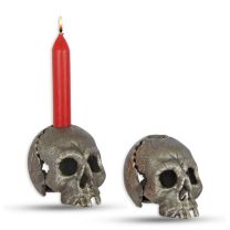 A CAST IRON SKULL CANDLE HOLDER, OLD SILVER