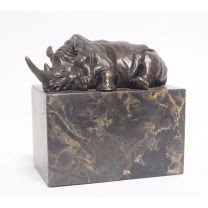A BRONZE SCULPTURE OF A LYING RHINOCEROS