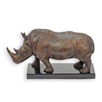 A BRONZE SCULPTURE OF A STANDING RHINO ON A MARBLE BASE